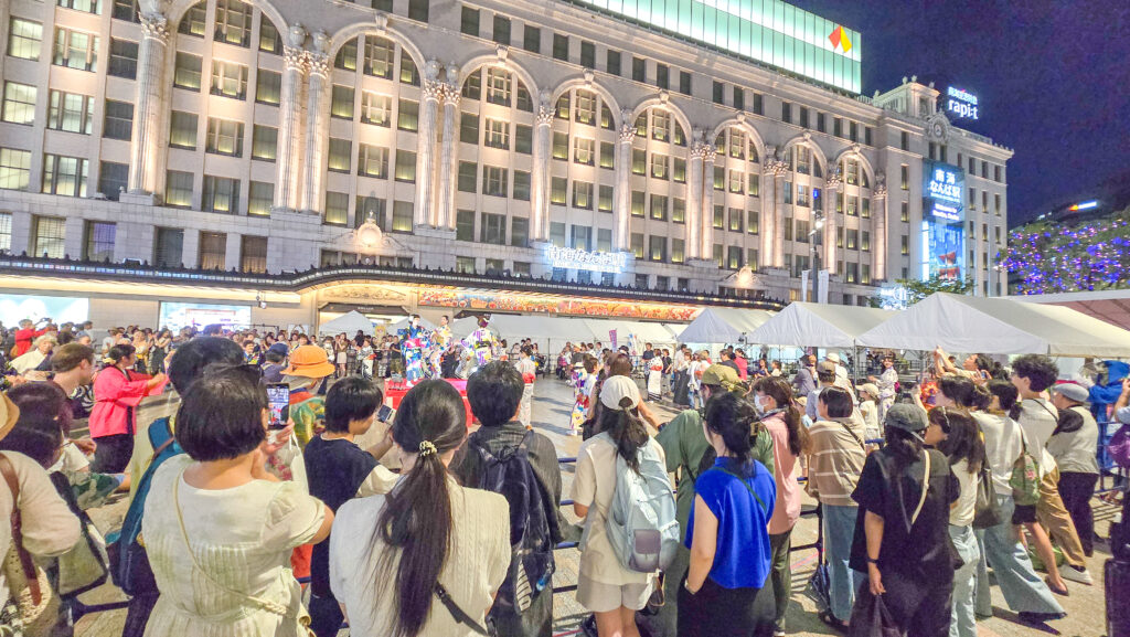 「大阪ミナミ夏祭り&にぎわいスクエア2025」の盆踊りで踊る人たちを観覧する人たち