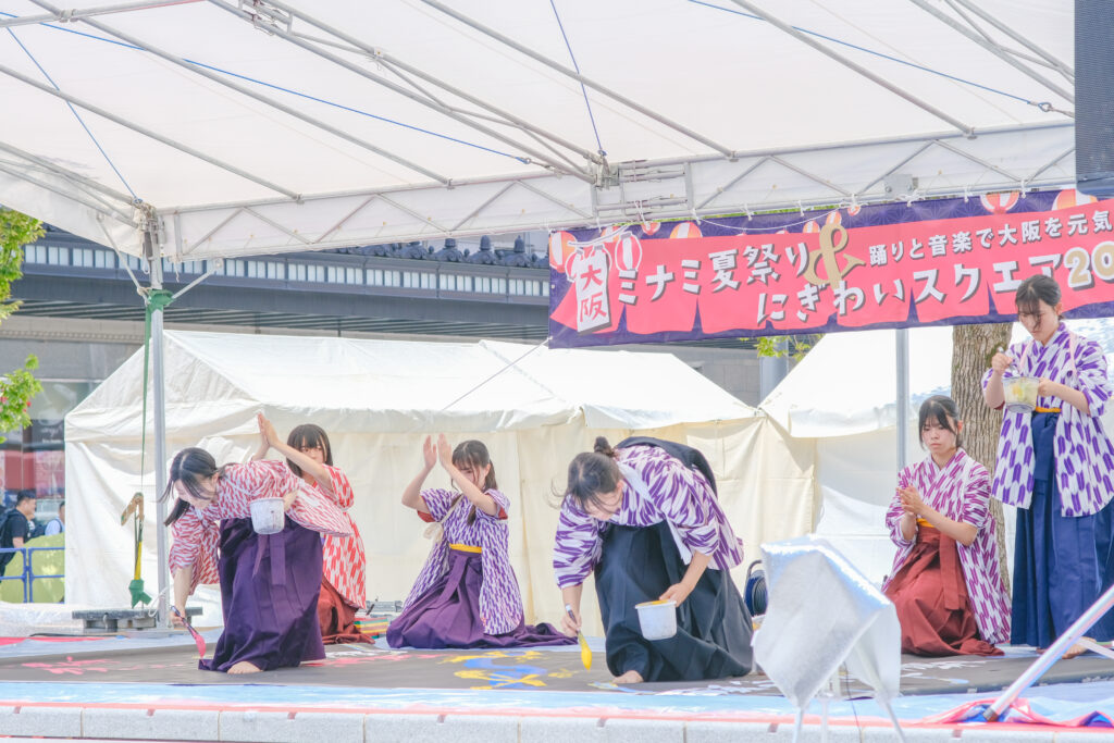 八尾高校書道部による、なんば広場で開催した大阪ミナミ夏祭り&にぎわいスクエア2025のオープニングアクトの様子