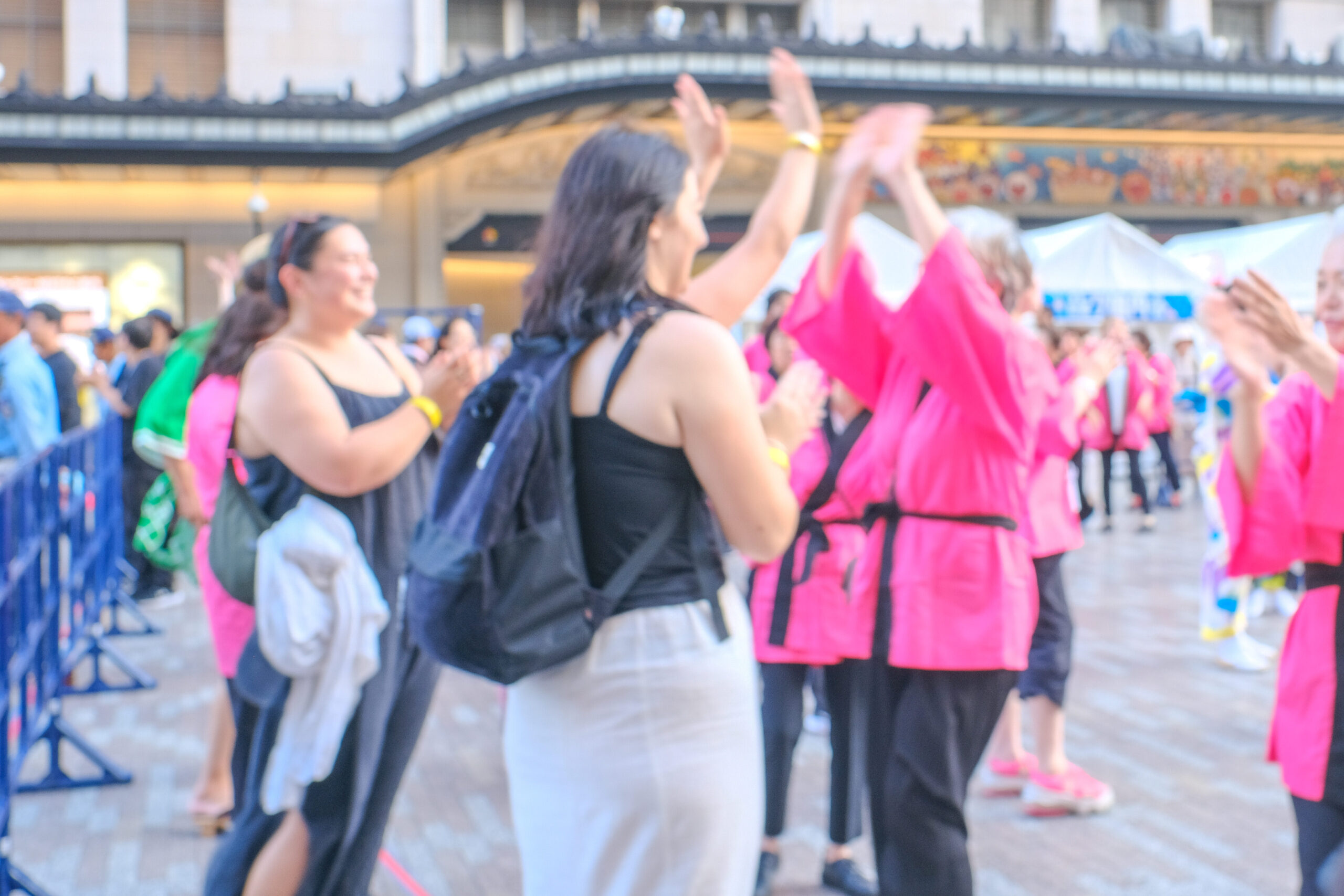 「大阪ミナミ夏祭り&にぎわいスクエア2025」の盆踊りで外国人観光客と地元の方がハイタッチをする様子